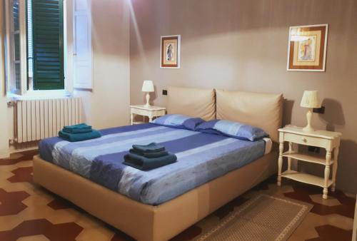 a bedroom with a large bed with blue sheets at Toselli Suite Apartment in Pisa