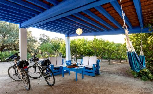 two bikes parked under a blue tent with a table and chairs at Monte do Serrado De Baixo in Évora