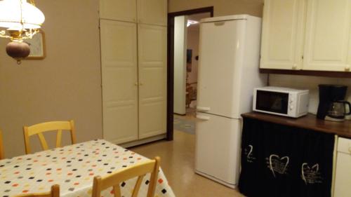 ヴァーサにあるNice spacious homeのテーブルと白い冷蔵庫のあるキッチン