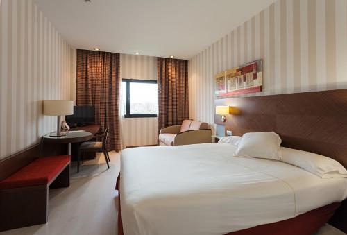 ein Hotelzimmer mit einem großen Bett und einem Schreibtisch in der Unterkunft Hotel Las Artes in Pinto