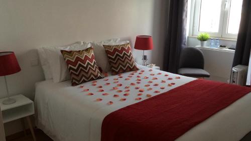 a bedroom with a bed with a red and white blanket at Aveiro White House in Aveiro