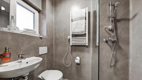 La salle de bains est pourvue de toilettes, d'un lavabo et d'une douche. dans l'établissement 24Seven Hotel Nürnberg, à Nuremberg