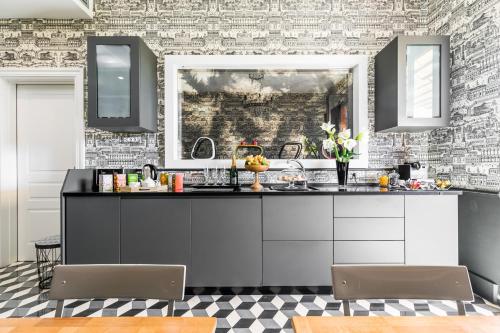 a kitchen with a black and white brick wall at Rarity Suites in Rome