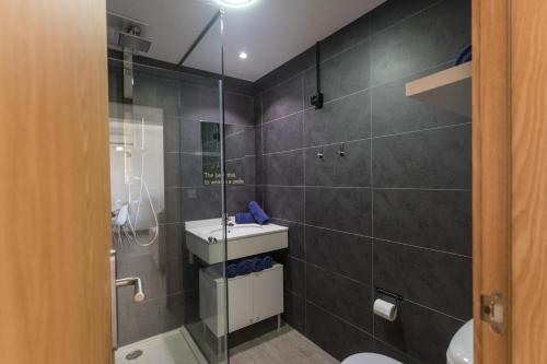 een badkamer met een douche, een toilet en een wastafel bij Galera Beach Apartamentos in Corralejo