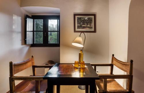 a dining room table with a lamp and two chairs at Monte do Serrado De Baixo in Évora