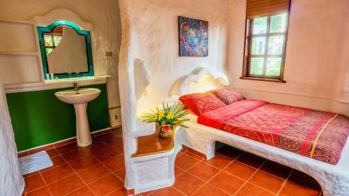 Schlafzimmer mit einem Bett, einem Waschbecken und einem Spiegel in der Unterkunft Atlantis Dive Resort Puerto Galera in Puerto Galera