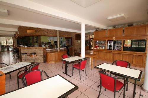 a restaurant with tables and chairs and a bar at Logis Auberge La Diege in Capdenac-Gare