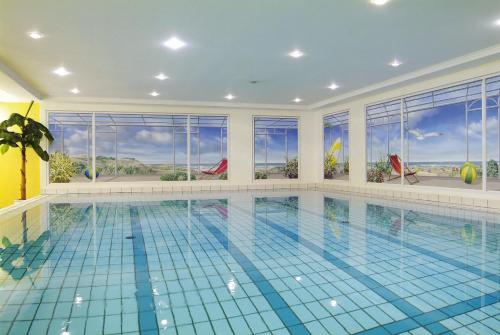 a swimming pool in a house with a large swimming pool at Strandhotel Gerken in Wangerooge