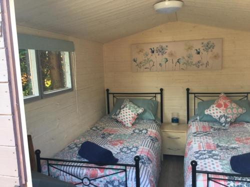 2 Betten in einem Zimmer mit 2 Fenstern in der Unterkunft Cherryberry Lodges in Abergavenny