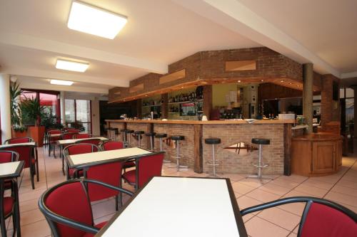 a restaurant with tables and chairs and a bar at Logis Auberge La Diege in Capdenac-Gare