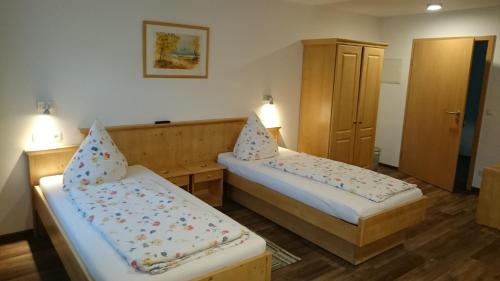 a small room with two beds and a cabinet at Mühldorfer Hof in Altötting