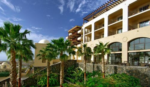 a building with palm trees in front of it at Vincci Selección La Plantación del Sur in Adeje