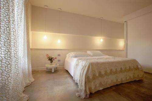 a bedroom with a white bed and a window at Shalai - Exclusive SPA and small gourmet hotel in Linguaglossa