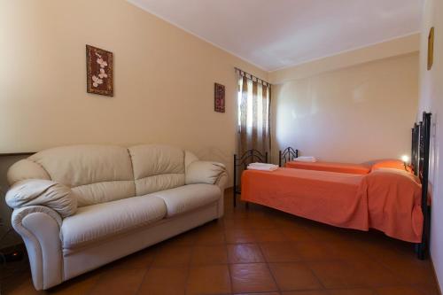 a living room with a couch and a bed at turismo rurale Il Sole in SantʼAngelo di Brolo