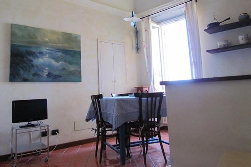 ein Esszimmer mit einem Tisch mit Stühlen und einem TV in der Unterkunft Gli appartamenti di Lorenzo in Cervo