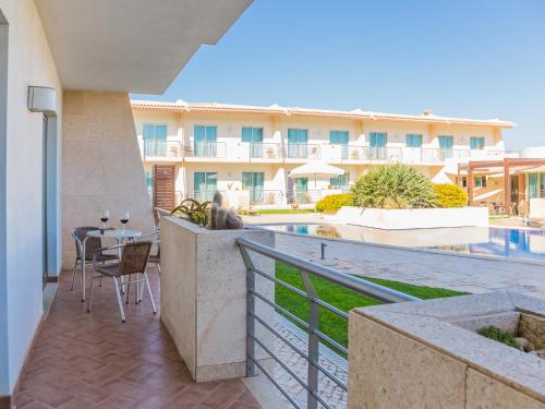 a balcony with a table and chairs and a building at Pontalaia Apartamentos Turísticos in Sagres