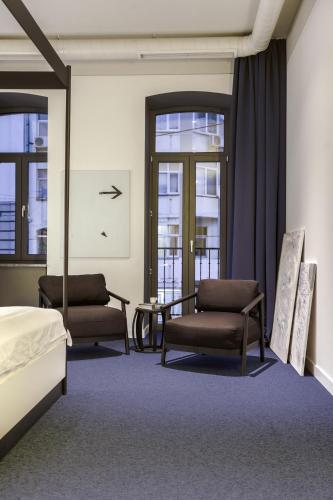 a bedroom with two chairs and a bed and a mirror at BURSA Hotel Kyiv in Kyiv