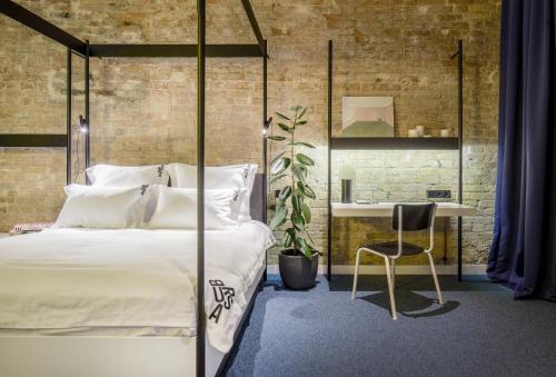 a bedroom with a bed and a desk and a chair at BURSA Hotel Kyiv in Kyiv