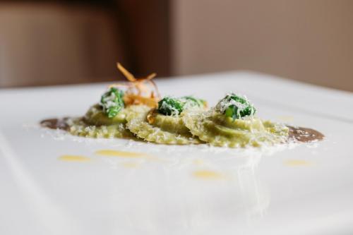 a plate of food with broccoli on a table at Shalai - Exclusive SPA and small gourmet hotel in Linguaglossa