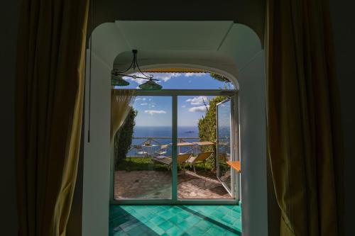 a room with a view of the ocean from a window at Bacio del Sole B&B Positano in Positano