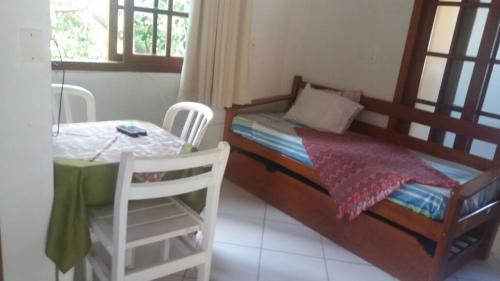 1 dormitorio pequeño con 1 cama, mesa y sillas en Residencial Tamy, en Florianópolis