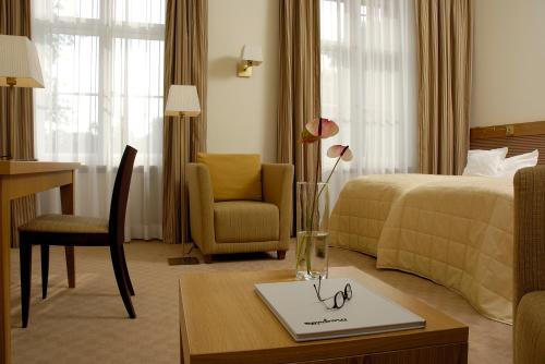 una habitación de hotel con una cama y una mesa con gafas. en Schloss und Gut Liebenberg, en Liebenberg