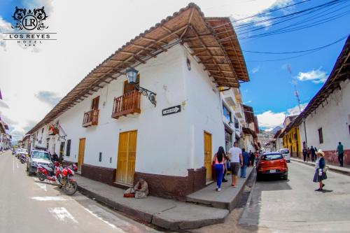 a group of people walking down a street next to a building at Hotel Los Reyes in Cajamarca