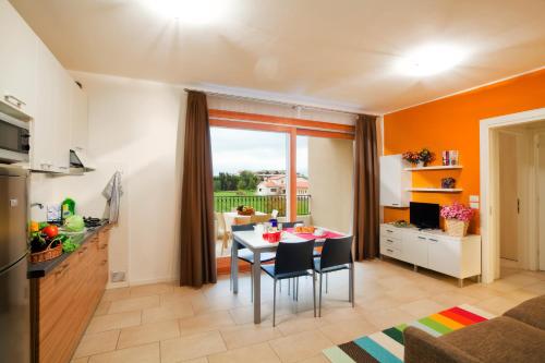 eine Küche und ein Wohnzimmer mit einem Tisch und Stühlen in der Unterkunft Villaggio A Mare in Caorle