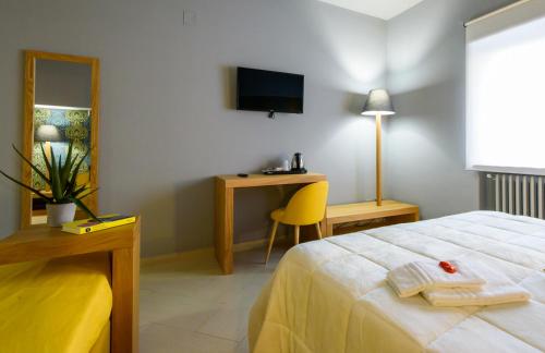 a bedroom with a bed and a desk with a television at Un B&B al Belvedere in Enna