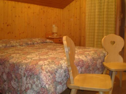 a bedroom with a bed and a chair and a table at Flora Quinz in Sappada