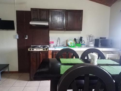 a kitchen with wooden cabinets and a table with a green table cloth at Hotel Gesa in Villa Corona