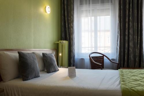 a bedroom with a bed with a sign on it at Logis Hotel & Restaurant La Paix in Le Nouvion-en-Thiérache