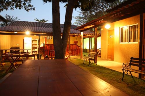 a patio with benches and a tree at night at Savana Hostel in Sao Jorge