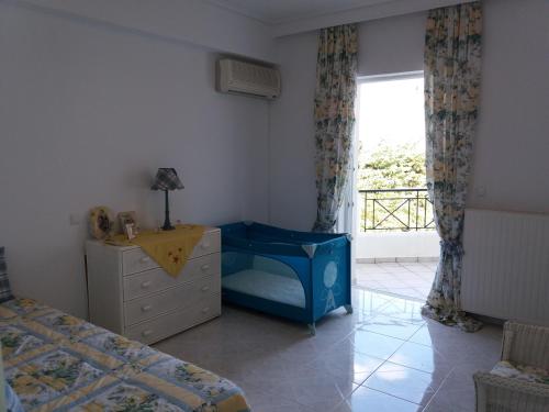 a bedroom with a bed and a dresser and a window at Beach House Villa in Nea Makri