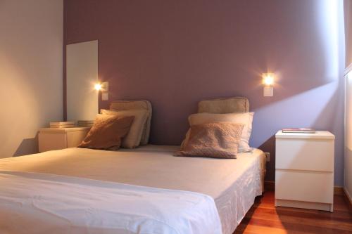 1 dormitorio con 1 cama blanca y 2 almohadas en Penthouse City Center apartment, en Ponta Delgada