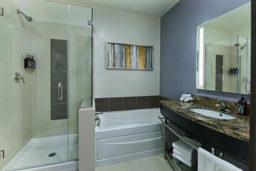 a bathroom with a shower and a sink and a tub at Oxford Suites Sonoma - Rohnert Park in Rohnert Park
