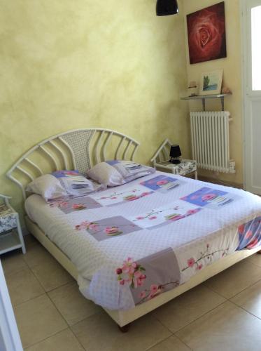Un dormitorio con una cama grande con flores. en La Petite Vendeenne en Brem-Sur-Mer