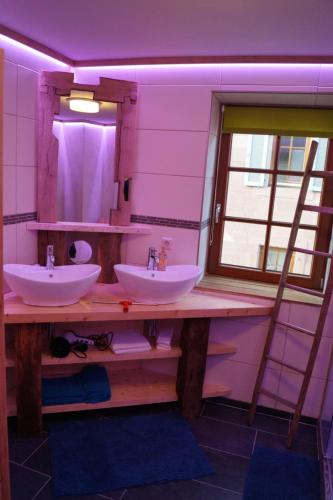 a bathroom with two sinks and a mirror at Muggel Apartments in Alpirsbach