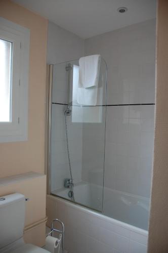 a bathroom with a shower and a toilet and a tub at The Originals City, Hôtel Le Savoy, Caen in Caen