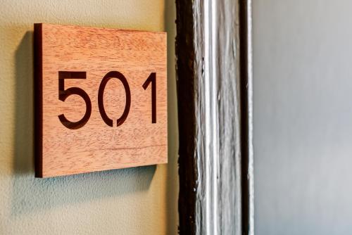 a wooden clock on a wall next to a door at The Bartlett Hotel and Guesthouse in San Francisco