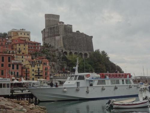 a boat in a harbor with a castle in the background at Affittacamere La Baia Di Lerici in Lerici