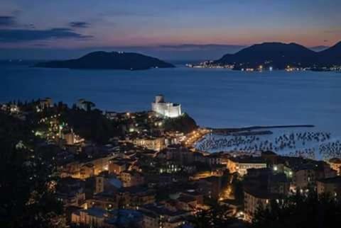 a view of a city at night with the water at Affittacamere La Baia Di Lerici in Lerici