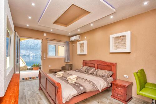 - une chambre avec un lit et une chaise verte dans l'établissement Apartments Bella Vista, à Kotor