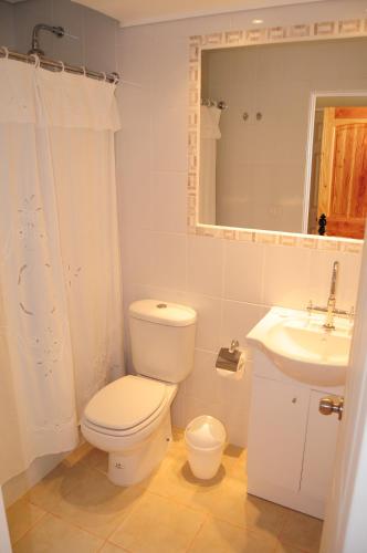 a white bathroom with a toilet and a sink at Hotel Altos de Tuqui in Ovalle