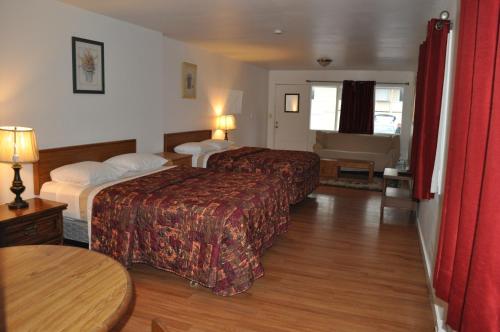 a hotel room with two beds and a table at Golden Lion Motel in Raymond