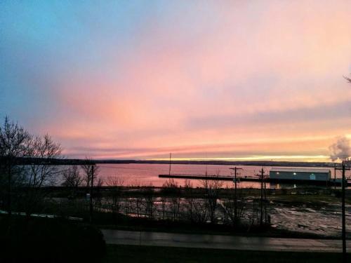 a sunset over a body of water with a train at Braeside Country Inn in Pictou