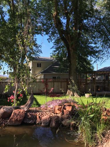 a pond in front of a house with a tree at Monroe Inn in Monroe