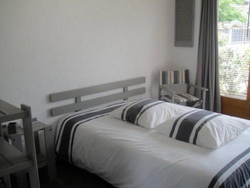 1 dormitorio con 2 camas y ventana en Le Chantemerle climatisé, en Briennon