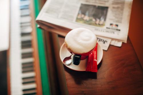 a cup of coffee sitting on a table next to a newspaper at Apartment Petra IV in Dubrovnik