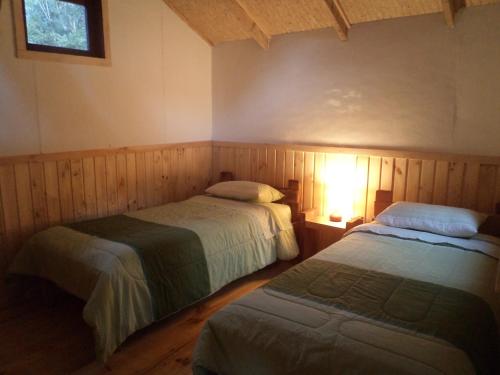 1 dormitorio con 2 camas y ventana en Alojamiento junto al mar, en Chaitén
